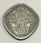 A silver pendant decorated with birds