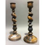 A pair of turned and carved wood candlesticks with acanthus leaf decoration