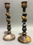 A pair of turned and carved wood candlesticks with acanthus leaf decoration