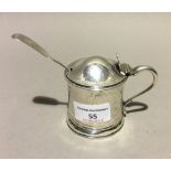 A silver mustard pot with liner and a silver spoon