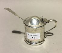 A silver mustard pot with liner and a silver spoon