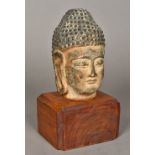 A Chinese terracotta Buddha's head Mounted on a later plinth base. 26 cm high overall.