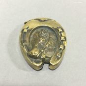 A brass vesta in the form of a horse's head in a horse shoe