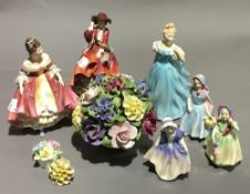 A collection of Doulton figurines and porcelain flowers