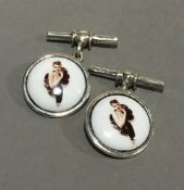 A pair of silver cufflinks each decorated with a lady