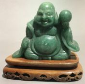 A jade Buddha on a wooden base