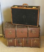 A vintage leather bound suitcase and two travelling trunks