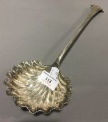 A large silver shell bowl ladle