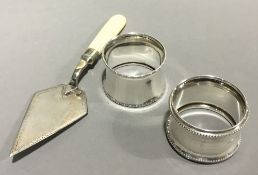 Two silver napkin rings and a plate trowel/cake slice with mother-of-pearl handle