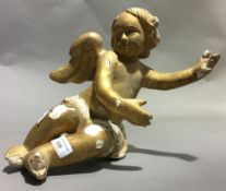 A gilt painted carved wooden cherub