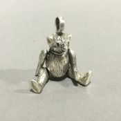 A miniature silver model of a teddy bear