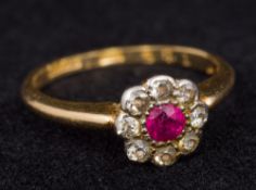 A gold, diamond and ruby set flowerhead ring Size K. Approximately 2 grammes all in.