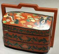 A Chinese lacquered three sectional box decorated with a dragon
