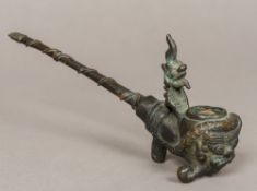 A Chinese cast metal opium pipe The bowl worked with a grotesque mask. 22 cm long.