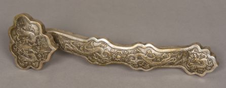 A Chinese silvered ruyi sceptre Typically worked with dragons chasing flaming pearls. 36.5 cm long.