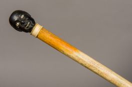 A 19th century ebony and whale bone walking stick The plain whalebone shaft with an ivory collar