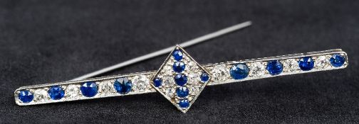 An Art Deco platinum, diamond and sapphire set bar brooch Centrally set with a stone filled lozenge.