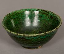 A Chinese combed peacock feather bowl Decorated with slip on a green ground. 11.5 cm diameter.