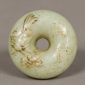 A small Chinese jade roundel Of pierced circular form, carved with a bird and calligraphy. 5.