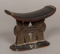 A South African Shona Tribe carved wood headrest The pillow supported on typically carved uprights,