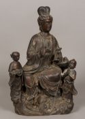 A Chinese gilt heightened patinated bronze model of Guanyin Modelled seated holding a ruyi sceptre