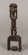 An African tribal carved wooden pulley The handle of figural form. 26 cm high.