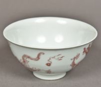 A Chinese porcelain bowl Worked with dragons chasing flaming pearls in iron red. 12.5 cm diameter.