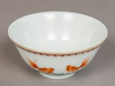 A Chinese porcelain bowl Worked with a goldfish above stylised waves,