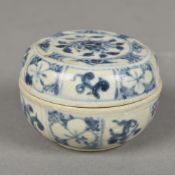 A Chinese blue and white pottery box and cover Of circular section, decorated with floral sprays.