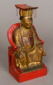 A Chinese lacquered and carved giltwood figure Modelled seated holding a ruyi sceptre. 24 cm high.