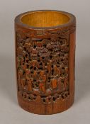 A Chinese carved bamboo brush pot Worked with figural and animal vignettes. 18.5 cm high.