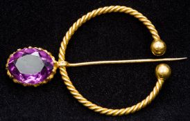 An unmarked 18 ct gold amethyst set brooch Of Celtic style. 4.5 cm wide.