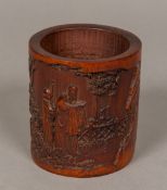 A Chinese carved bamboo brush pot Worked with figures in a fenced mountainous landscape, signed.