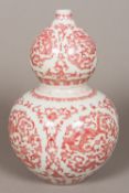 A Chinese porcelain double gourd vase Iron red decorated with dragons amongst floral strapwork,
