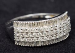 A 9 ct white gold diamond ring Set with three rows of brilliant cut diamonds flanked by two rows of