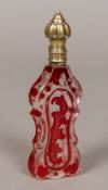 A 19th century ruby and clear glass scent bottle Of flattened waisted form with silver hinged lid.