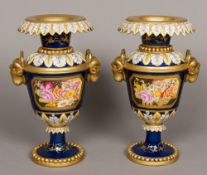 A pair of Sevres type twin handled vases Each with ram mask handles and floral painted vignettes