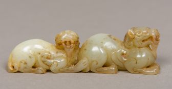 A Chinese carved pale and russet jade group Worked as a pair of temple lions. 9 cm long.