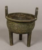 An antique Chinese patinated bronze censer The twin loop handles above the main bulbous body
