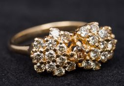 A 14 ct gold diamond set cluster ring Of bow form. 2 cm wide.