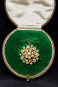 A Victorian unmarked gold, seed pearl set pendant/brooch Of domed pierced floral form,