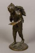 A Japanese Meiji period patinated bronze figure Modelled as a young man reading a book whilst