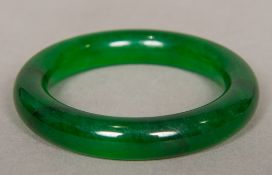 A Chinese carved spinach jade bangle 8 cm diameter.