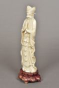 A late 19th/early 20th century Chinese carved ivory figure of a sage Standing on a carved wood