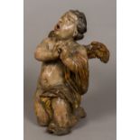 A 17th century carved wooden figure of a cherub Modelled kneeling at prayer,