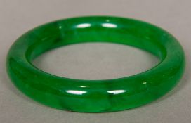 A Chinese carved spinach jade bangle 8.5 cm diameter.