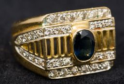 An 18 ct gold diamond and sapphire set gentleman's ring The central stone oval cut.