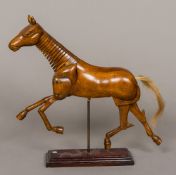 A stained wood articulated model of a horse Supported on a plinth base. 27 cm high.