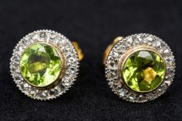 A pair of unmarked diamond and peridot set ear studs Each of target form. Each approximately 1.