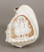 A cameo carved conch shell The shell of typical form, one side carved with three classical maidens.